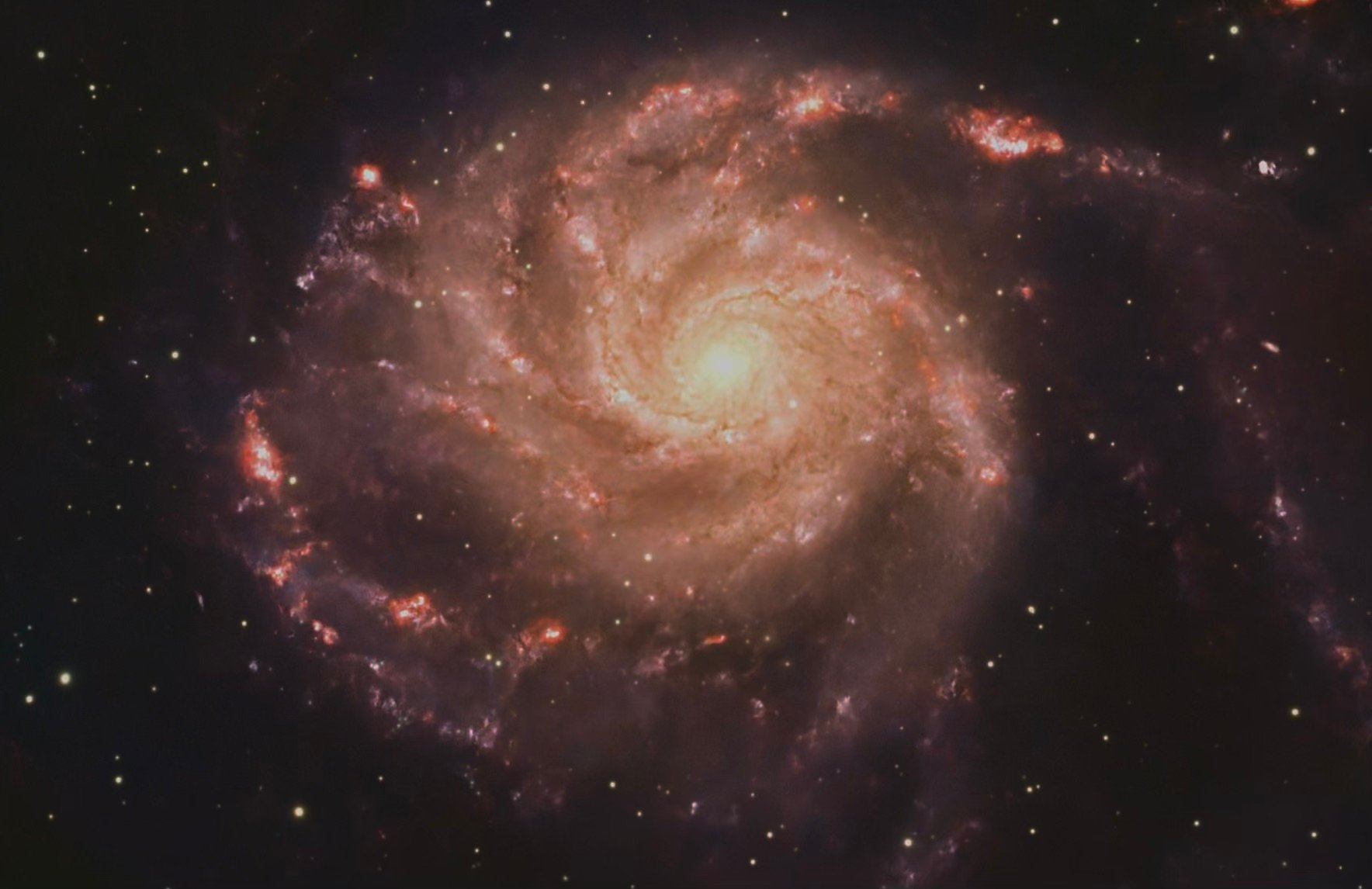Stunning spiral galaxy with bright core and colorful nebulae in space.